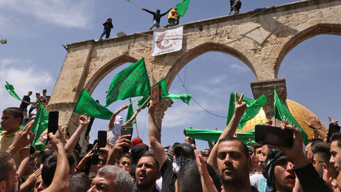 Manifestantes palestinos con banderas de Hamás en el Monte del Templo durante el Ramadán. (AFP) Manifestantes palestinos con banderas de Hamás en el Monte del Templo durante el Ramadán.