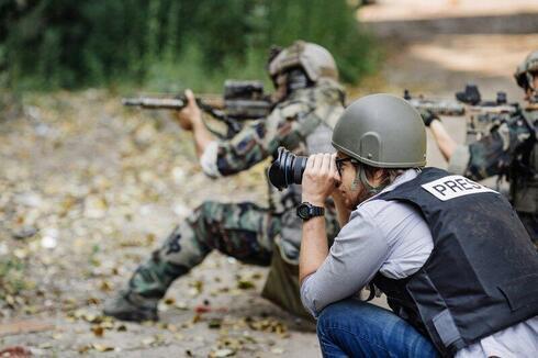Un fotógrafo cubriendo a las tropas durante los combates.