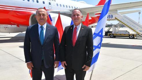 El ministro de Relaciones Exteriores de Turquía, Mevlut Cavusoglu (izquierda), con un dignatario del Ministerio de Relaciones Exteriores en el aeropuerto Ben Gurion. 