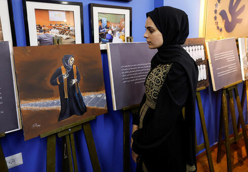Zainab al-Qolaq, artista de Gaza de 22 años, exhibe sus pinturas en la ciudad de Gaza. 