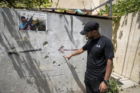 El palestino Salim Wad señala los agujeros de bala de un tiroteo entre militantes palestinos y soldados israelíes en un callejón estrecho, a unos 300 metros de donde fue baleada Shireen Abu Akleh. 