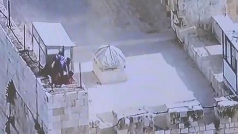 Manifestantes palestinos arrojan piedras a la policía en el Monte del Templo el domingo. 