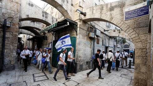 Jóvenes religiosos caminan con una bandera israelí por la ciudad vieja de Jerusalem el domingo antes de la Marcha de las Banderas. (Reuters) Jóvenes religiosos caminan con una bandera israelí por la ciudad vieja de Jerusalem el domingo antes de la Marcha de las Banderas.