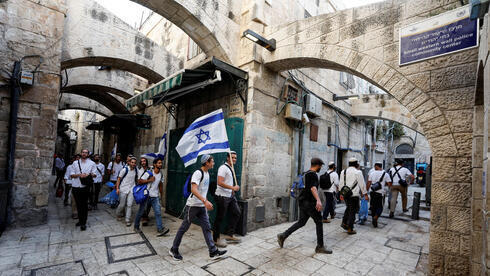 Jóvenes religiosos caminan con una bandera israelí por la ciudad vieja de Jerusalem el domingo antes de la Marcha de las Banderas. 