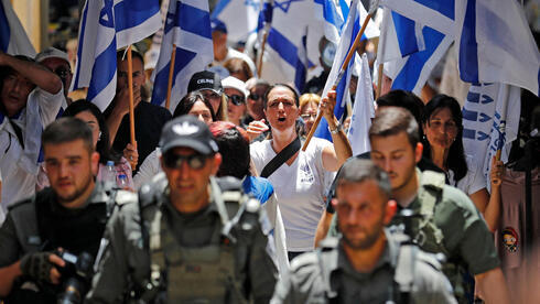 Jóvenes israelíes con banderas marchan por la Ciudad Vieja de Jerusalem el domingo. 