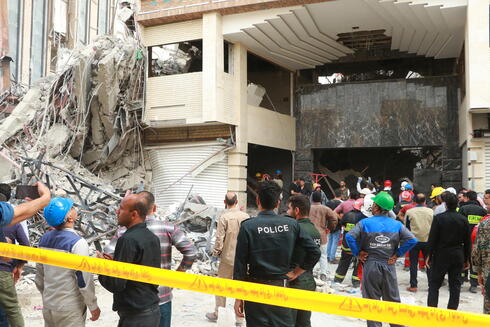 Personas se acercan al edificio derrumbado en Irán.
