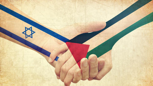 Israelíes y palestinos cogidos de la mano.
