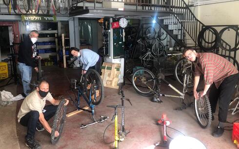 Personas reparan bicicletas en el taller de Tel Aviv.  