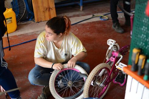 Dina Melamed arregla una bicicleta en Pnimit en Yafo. 