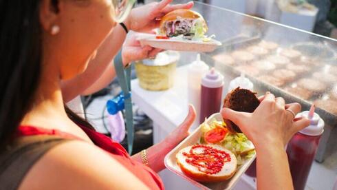 Participantes del Vegan Fest disfrutando de hamburguesas de origen vegetal.
