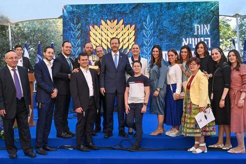 El presidente Isaac Herzog y la primera dama Michal Herzog flanqueados por los ganadores del Premio Presidencial al Voluntariado 2022. (GPO) El presidente Isaac Herzog y la primera dama Michal Herzog flanqueados por los ganadores del Premio Presidencial al Voluntariado 2022.
