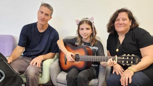 Margarita y su nueva guitarra, junto a su madre y su profesor de colegio. 