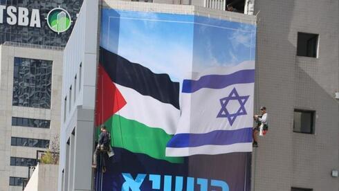 Pancarta de Shalom Ajshav con las banderas israelí y palestina. 