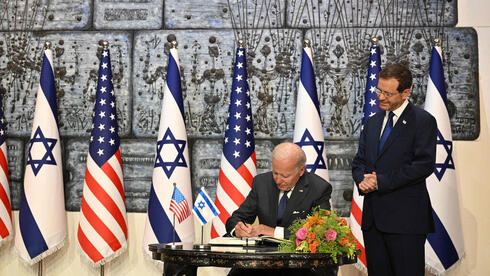 Biden firma el libro de visitas de la residencia oficial con Herzog a su lado. 