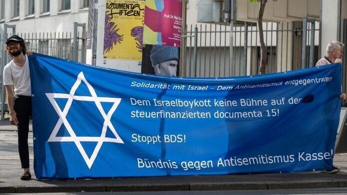Una pancarta denuncia las obras con contenido antisemitas que se mostraron en una importante muestra de arte en Alemania.