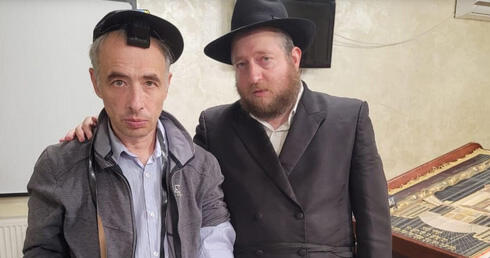 El rabino Shaul Horowitz, a la derecha, se reúne con un refugiado judío que asiste al servicio en la sinagoga de Vinnytsia, Ucrania, en junio de 2022. 