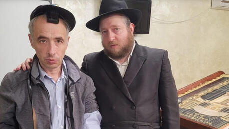 El rabino Shaul Horowitz, a la derecha, se reúne con un refugiado judío que asiste al servicio en la sinagoga de Vinnytsia, Ucrania, en junio de 2022.