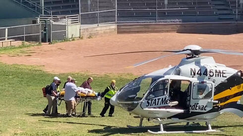 Momento en que Rushdie es subido en camilla en helicóptero para ser trasladado hacia un avión que lo llevaría al hospital. 