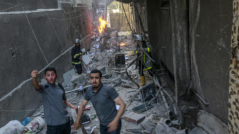 Palestinos en Gaza cerca de un edificio atacado por las FDI. 