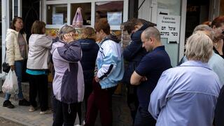 Refugiados forman una fila para recibir alimentos en Umán. 