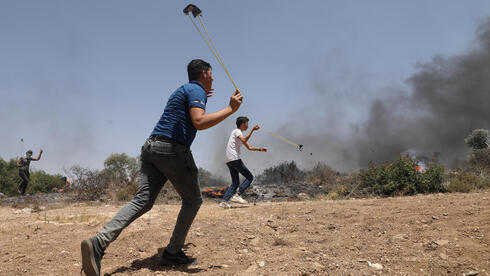 Palestinos lanzan piedras a las tropas israelíes en Cisjordania. 