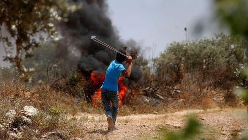 Palestinos lanzan piedras en Cisjordania. 