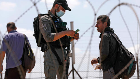 Un oficial de la Policía de Fronteras verifica los documentos de un palestino en el cruce desde Jenin