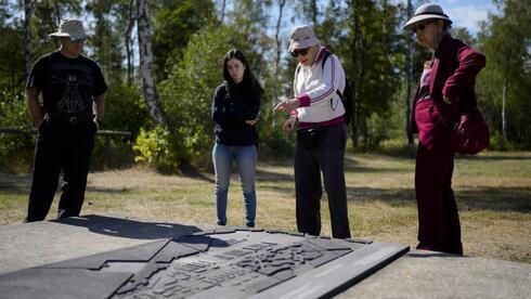 Shaul Ladany, segundo a la derecha, con familiares frente a una maqueta en miniatura del antiguo campo de concentración nazi de Bergen-Belsen