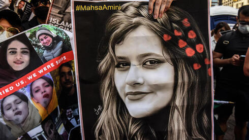Manifestantes sostienen una foto de Mahsa Amini durante una protesta antigubernamental en Irán 