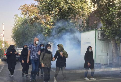 En esta foto de la semana pasada, frente a la Universidad de Teherán, se ve a jóvenes huyendo de los gases lacrimógenos disparados por la policía iraní. (vía AP) Imagen de las protestas en Irán.