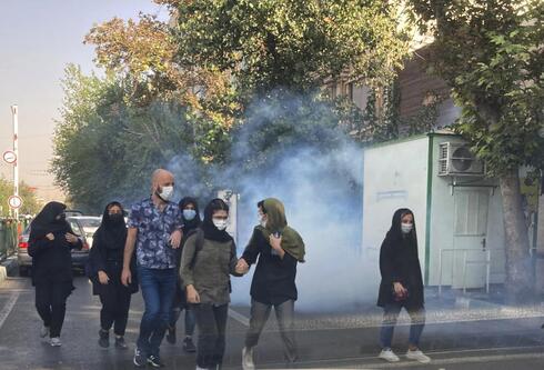 En esta foto de la semana pasada, frente a la Universidad de Teherán, se ve a jóvenes huyendo de los gases lacrimógenos disparados por la policía iraní. 