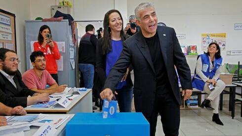 Lapid y su esposa Lihi votando en un colegio electoral en Tel Aviv durante las elecciones parlamentarias de marzo del año pasado