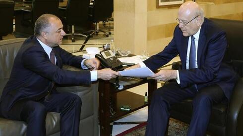 El primer ministro libanés, Najib Makati, a la derecha, recibe el borrador final del acuerdo sobre la frontera marítima entre Líbano e Israel de manos de su adjunto Elias Bou Saab.