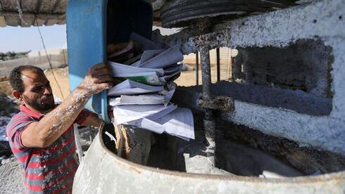 Un trabajador palestino prepara residuos de papel durante un proceso para reciclarlos en bandejas de huevos. 