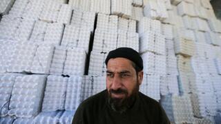 Un trabajador palestino frente a bandejas de huevos recién hechas, fabricadas con desechos de papel reciclado. 