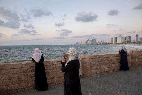 Mujeres árabes sacan fotos al mar en Jaffa. La minoría árabe israelí se vio favorecida por algunas políticas de la coalición política saliente. 