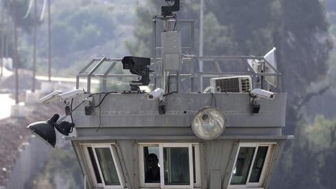 Dos pistolas robóticas se sitúan en lo alto de una torre de vigilancia erizada de cámaras que apuntan al campo de refugiados de Aroub, en Cisjordania, el jueves 6 de octubre de 2022. 