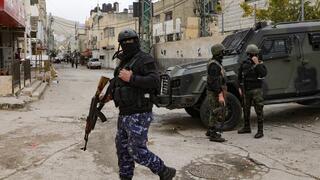 Fuerzas de seguridad de la Autoridad Palestina con pasamontañas junto a un vehículo blindado a la entrada del campamento de Balata, cerca de la ciudad cisjordana de Naplusa.