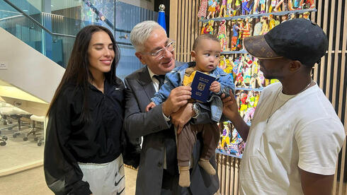 El embajador Hayek alza al primer niño nacido en Emiratos Árabes Unidos que recibe un pasaporte israelí. 