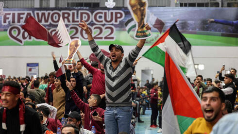 Aficionados palestinos miran el partido inaugural del Mundial de Fútbol en una pantalla gigante en Gaza. 