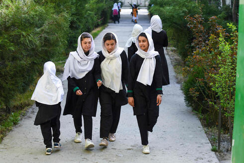 Niñas yendo a un colegio poco antes de que se prohiba su asistencia a colegios. 