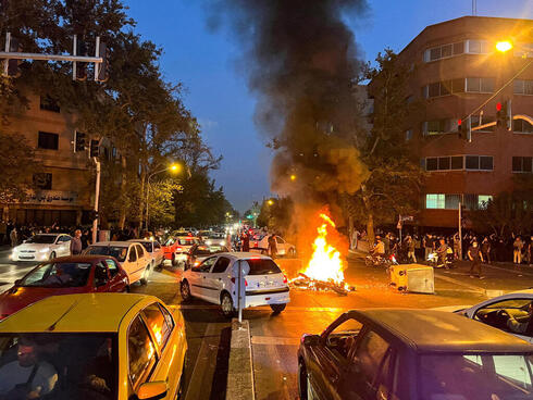 Manifestantes antigubernamentales iraníes prenden fuego a una motocicleta, el 19 de septiembre de 2022.