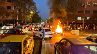 Manifestantes antigubernamentales iraníes prenden fuego a una motocicleta, el 19 de septiembre de 2022.