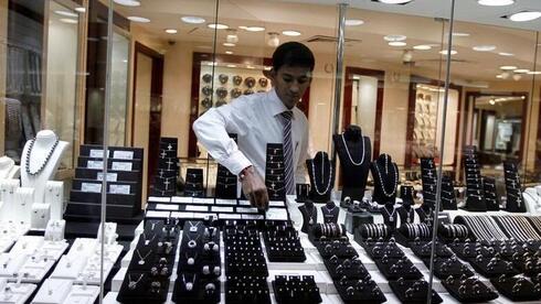 Un empleado de una joyería coloca un diamante en el escaparate del Parque del Oro y el Diamante de Dubai.