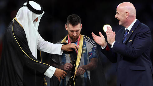 El emir de Catar coloca la abaya a Messi durante la entrega de premios junto a Gianni Infantino. 