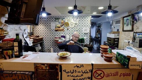 El propietario del famoso restaurante Abu Shukri prepara un tazón de hummus a base de garbanzos en la Ciudad Vieja de Jerusalem. 