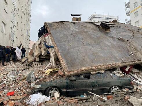 arias personas buscan entre los escombros tras un terremoto en Diyarbakir, Turquía, el 6 de febrero de 2023.