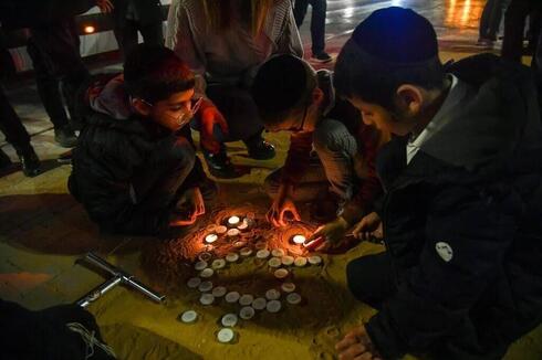 Civiles encienden velas en el lugar del mortal tiroteo terrorista en el barrio Neve Yaakov de Jerusalem, el mes pasado.