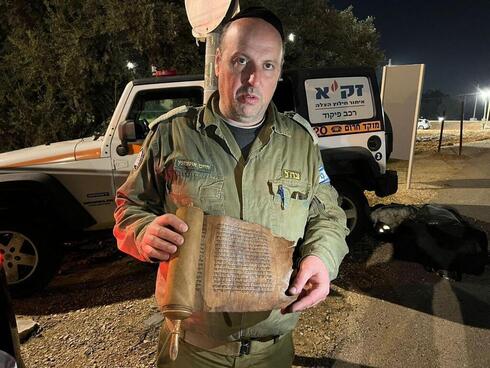 Comandante del equipo de rescate israelí sosteniendo los pergaminos.