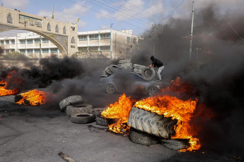 Manifestantes palestinos queman neumáticos para bloquear una carretera de acceso a Jericó tras una incursión de las FDI la semana pasada. 